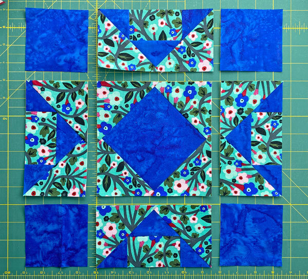 Arrange the sewn patches and cut square into the Cross and Square block design Arrange the sewn patches and cut square into the Cross and Square block design