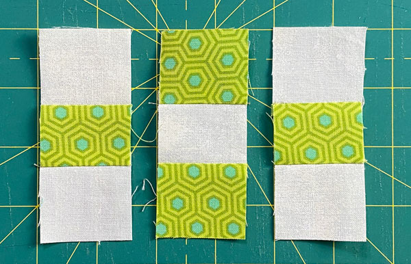 The 3 strata ready to stitch together into a 9-patch with light squares in the corners The 3 strata ready to stitch together into a 9-patch with light squares in the corners