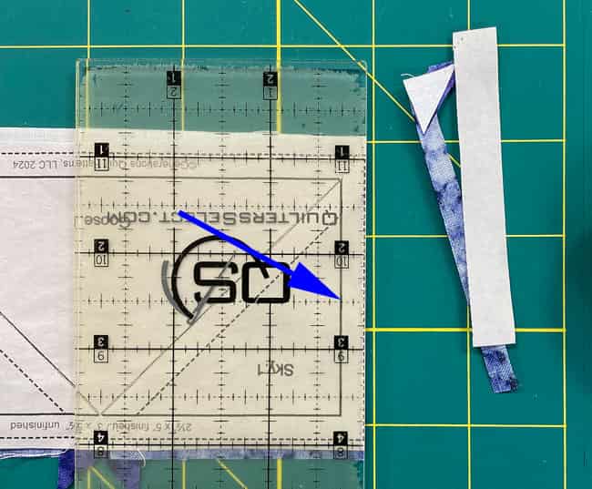 Trim away the excess fabric and paper pattern from the first side of a FG Trim away the excess fabric and paper pattern from the first side of a FG