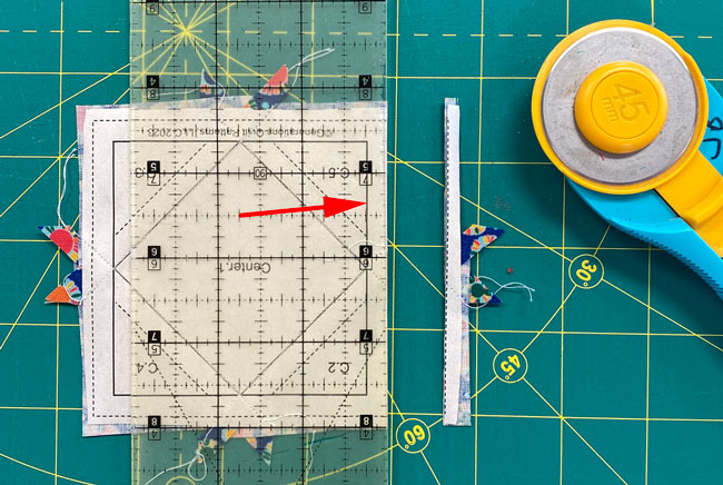 Position the 1/4" mark on the ruler with the solid line and trim away the excess
