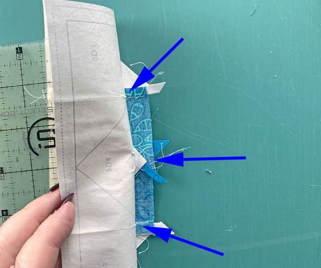 Pulling the pattern away from the stitches before creasing and folding it back on itself