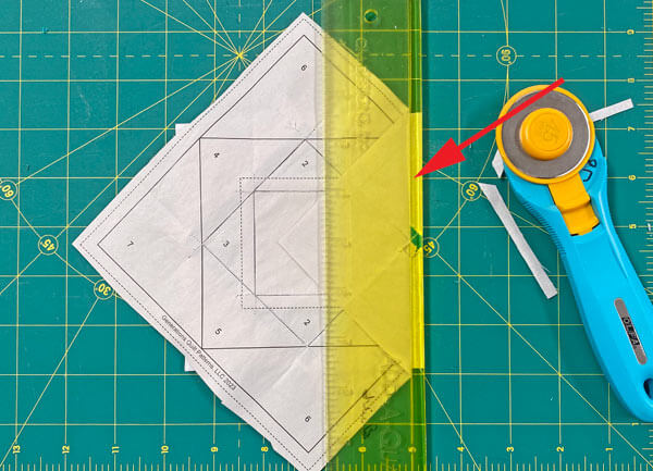 Fold the pattern back on itself on the line, position the ruler and trim away the excess