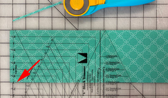 Aligning the V-block ruler with the bottom edge of the strip Aligning the V-block ruler with the bottom edge of the strip