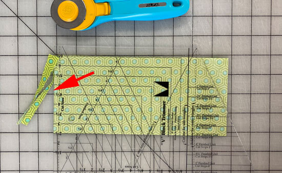 Using the V-Block Ruler to straighten a short edge of a pair of strips or a single folded strip Using the V-Block Ruler to straighten a short edge of a pair of strips or a single folded strip
